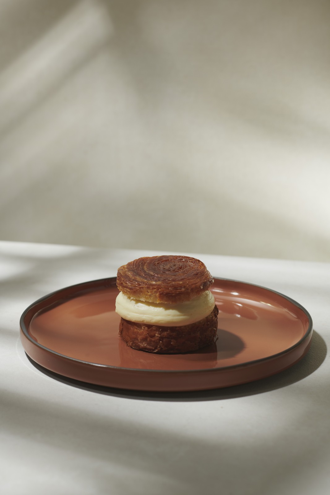 Revol Caractère Teller mit feinem Dessert und natürlichen Lichtreflexen